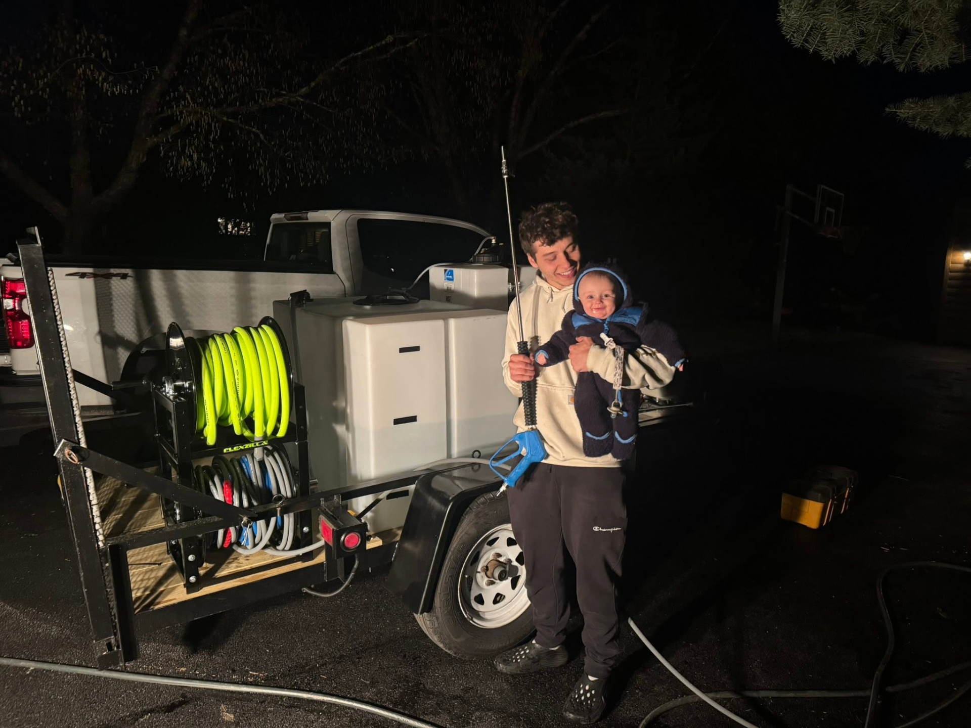 Aydan Digrugilliers with his son beside the Dirty Dawg soft-wash trailer